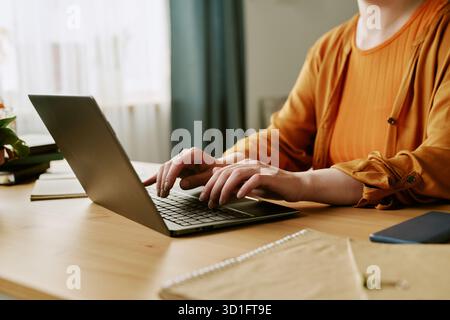 Young Adult Woman Typing on Laptop While Working in Home Office Stock Photo