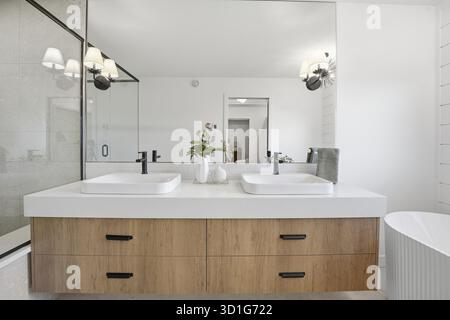 Bathroom with two sinks and a bathtub. The sinks are white and the bathtub is white Stock Photo