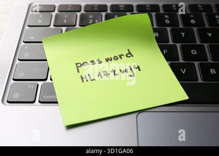 Sticky note with password on laptop, closeup Stock Photo