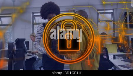 Four cybersecurity professionals analyzing holographic padlock overlay in open-plan office Stock Photo