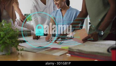 Four women collaborating over blueprints around table in studio, with holographic lock overlay Stock Photo
