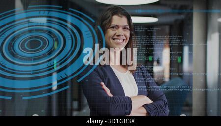Standing woman wearing blazer in corridor, with glass wall projecting holographic code interface Stock Photo