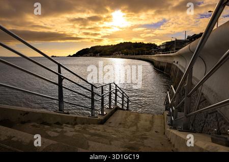 Mumbles seafront is a coastal area in Swansea, Wales, known for its picturesque views, the historic Mumbles Pier, and a recently redeveloped promenade Stock Photo