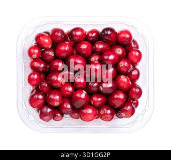 Fresh cranberries, bearberries, or American cranberries, in a clear plastic container, from above. Ripe, bright red, large cranberries. Stock Photo