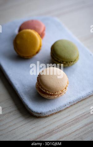 colourful French macarons in pistachio green, raspberry pink, lemon yellow, and vanilla beige shades. Stock Photo