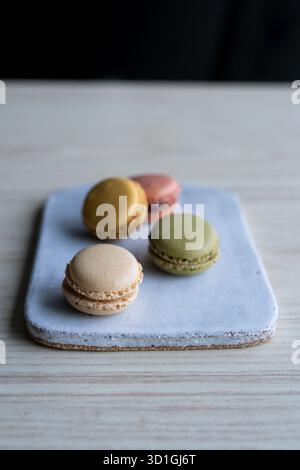 colourful French macarons in pistachio green, raspberry pink, lemon yellow, and vanilla beige shades. Stock Photo