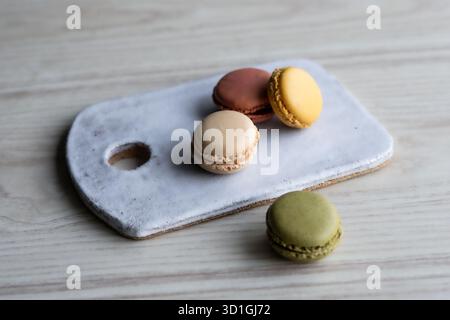 colourful French macarons in pistachio green, raspberry pink, lemon yellow, and vanilla beige shades. Stock Photo