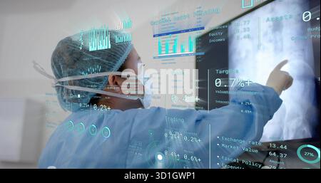 Pointing doctor in scrubs in exam room, using display showing X-ray arm, financial data, copy space Stock Photo