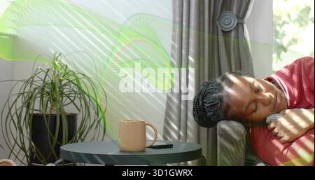 Reclining woman wearing red long-sleeve top on living room sofa, with mug smartphone, copy space Stock Photo