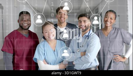 Smiling scrub-clad medical staff standing in hospital hall, with stethoscope and network icons Stock Photo