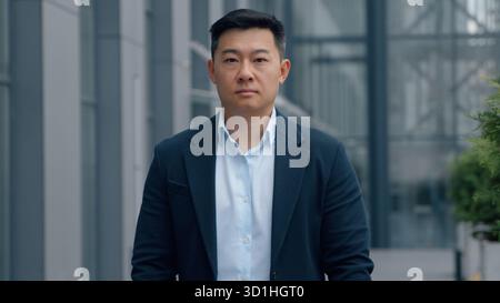 Asian Korean business man Chinese Japanese businessman portrait in city adult middle-aged serious confident male worker investor company CEO executive Stock Photo
