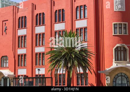 Vibrant red Art Deco building with palm tree in Mexico City — geometric architecture and modernist facade under bright sunlight Stock Photo