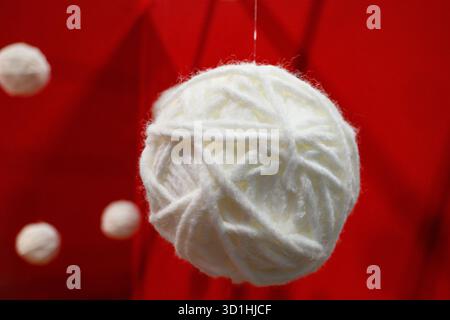 Ball of white wool on red background Stock Photo