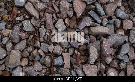 Close-up view of natural gravel stones with mixed colors and rough textures. This high-quality background image can be used for construction themes, l Stock Photo