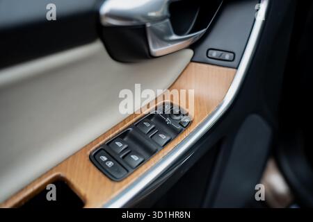 Modern car door panel with wooden trim and control buttons for windows and mirrors showcasing premium automotive interior materials and ergonomic desi Stock Photo