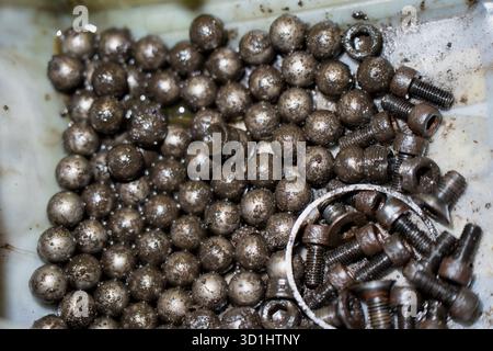 Grease-covered steel ball bearings and hardware in workshop setting highlighting industrial repair culture, engineering precision, and realistic detai Stock Photo