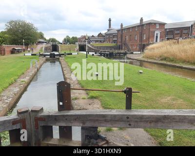 Two parallel, narrow, canal waterways with lock gates within the site of the National Waterways Museum at Ellesmere Port; & the Pattern Shop building. Stock Photo