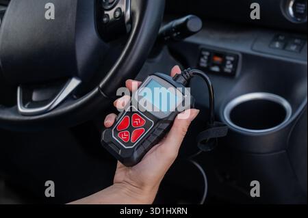 Woman using OBD2 diagnostic scanner.  Stock Photo