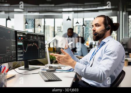 Financial advisor in office talking in mic, working with clients to develop personalized investing strategies for wealth growth. Investment consultant talking with customers, providing advice Stock Photo