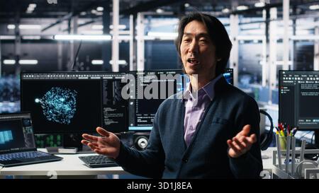 Smiling data center manager filming presentation, showcasing equipment using AI tech. Happy businessman presenting server room built for digital storage systems using artificial intelligence, camera A Stock Photo