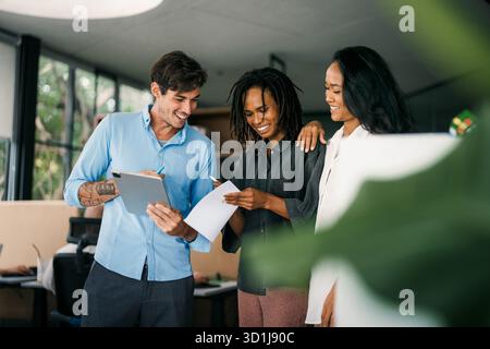 A diverse, talented team collaborates effectively in a bright office space during a business meeting Stock Photo