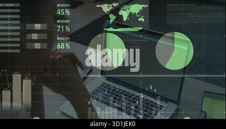Analyzing woman using silver laptop at office desk, with translucent charts stylus and green tablet Stock Photo