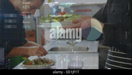 Working chefs wearing aprons plating fresh salads on plates in restaurant kitchen, data overlays Stock Photo