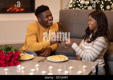 Happy Black Couple Celebrating Valentine's Day With Wine and Dinner at Home Stock Photo
