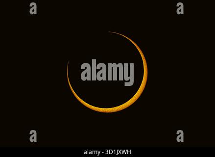 Annular solar eclipse in 2023, when the dark disc of the moon started to cover the disc of the sun. Stock Photo