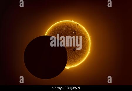 Partial phase of annular solar eclipse in 2023, when the dark disc of the moon started to cover the disc of the sun. Stock Photo