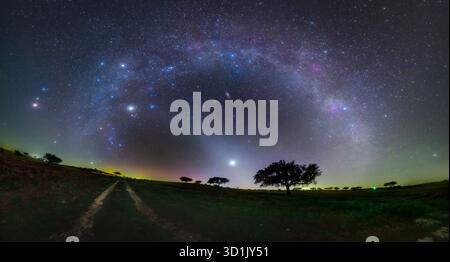 Zodiacal light shining along the ecliptic plane, highlighting some of the brightest planets visible in the winter starry skies. Image captured in the Dark Sky Alqueva Reserve, Campinho, Portugal. Stock Photo