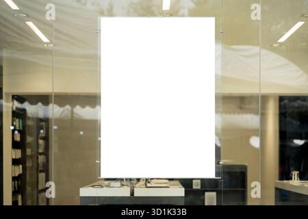 Empty white poster hanging on transparent glass wall inside modern retail shop, perfect for advertising design, marketing display, branding concept, p Stock Photo