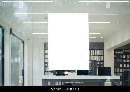 Empty white poster hanging on glass wall of modern shop interior, perfect for advertising, marketing, branding, product promotion, and business design Stock Photo