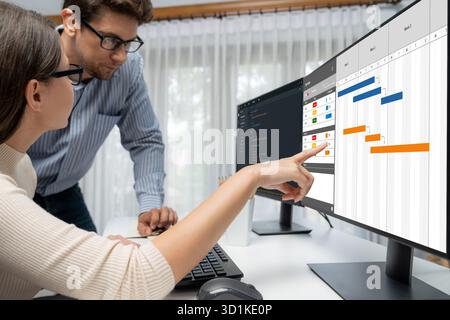Project planning software for brisk business project management on the computer screen showing timeline chart of the team project Stock Photo