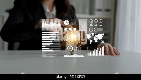A businesswoman engages with innovative technology in a modern workspace, utilizing virtual interfaces to analyze data and generate creative ideas Stock Photo