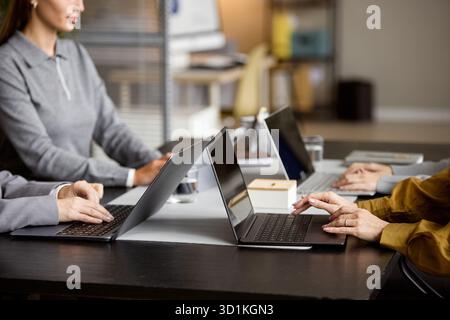 Caucasian Woman and Colleagues Collaborating on Laptops in Office Stock Photo