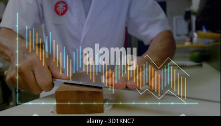 Senior Japanese chef in white coat sharpening knife on whetstone at kitchen counter, with avocado Stock Photo