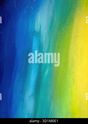 Painted wall with a color gradient from blue to yellow as a background Stock Photo