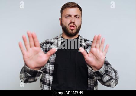Man in plaid shirt making a stop gesture with both hands. Stock Photo