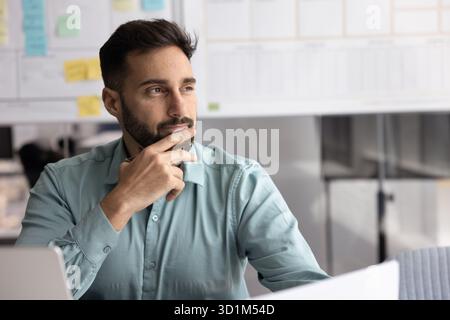 Male business planner looking aside from notebook holding papers pen Stock Photo