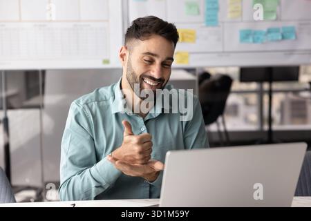 Friendly young businessman consult client by videocall using hand gestures Stock Photo