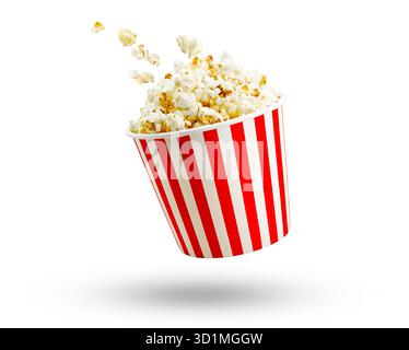 Popcorn flying out of red white striped paper box isolated on white background. Splash, levitation of popcorn grains. Stock Photo