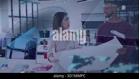 Reviewing two architects examining blueprint in open-plan office, with holographic overlays Stock Photo