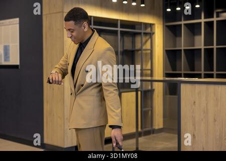 In the hotel. Young well-dressed businessman in a hotel waiting for a room Stock Photo