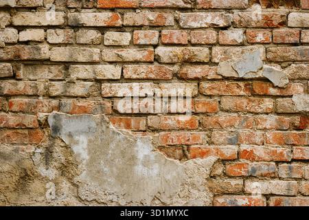 Part of weathered brick wall covered with plaster, backdrop Stock Photo
