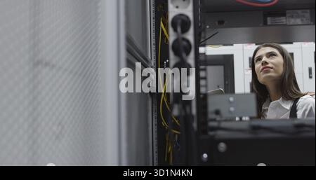 Technicians using laptop while analyzing server in server room Stock Photo