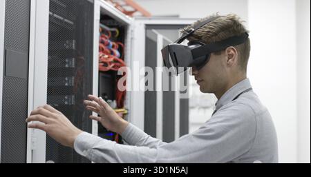 Young IT engeneer using virtual reality headset over server room background Stock Photo