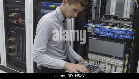 Technician performing maintenance tasks in a server room rack Stock Photo