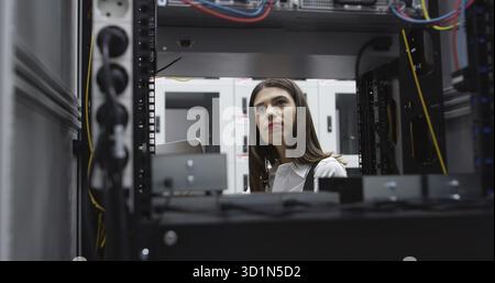 Technicians using laptop while analyzing server in server room Stock Photo