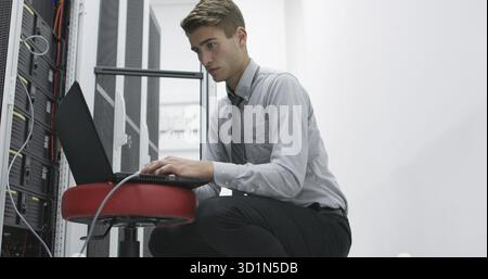 Technician performing maintenance tasks in a server room rack Stock Photo
